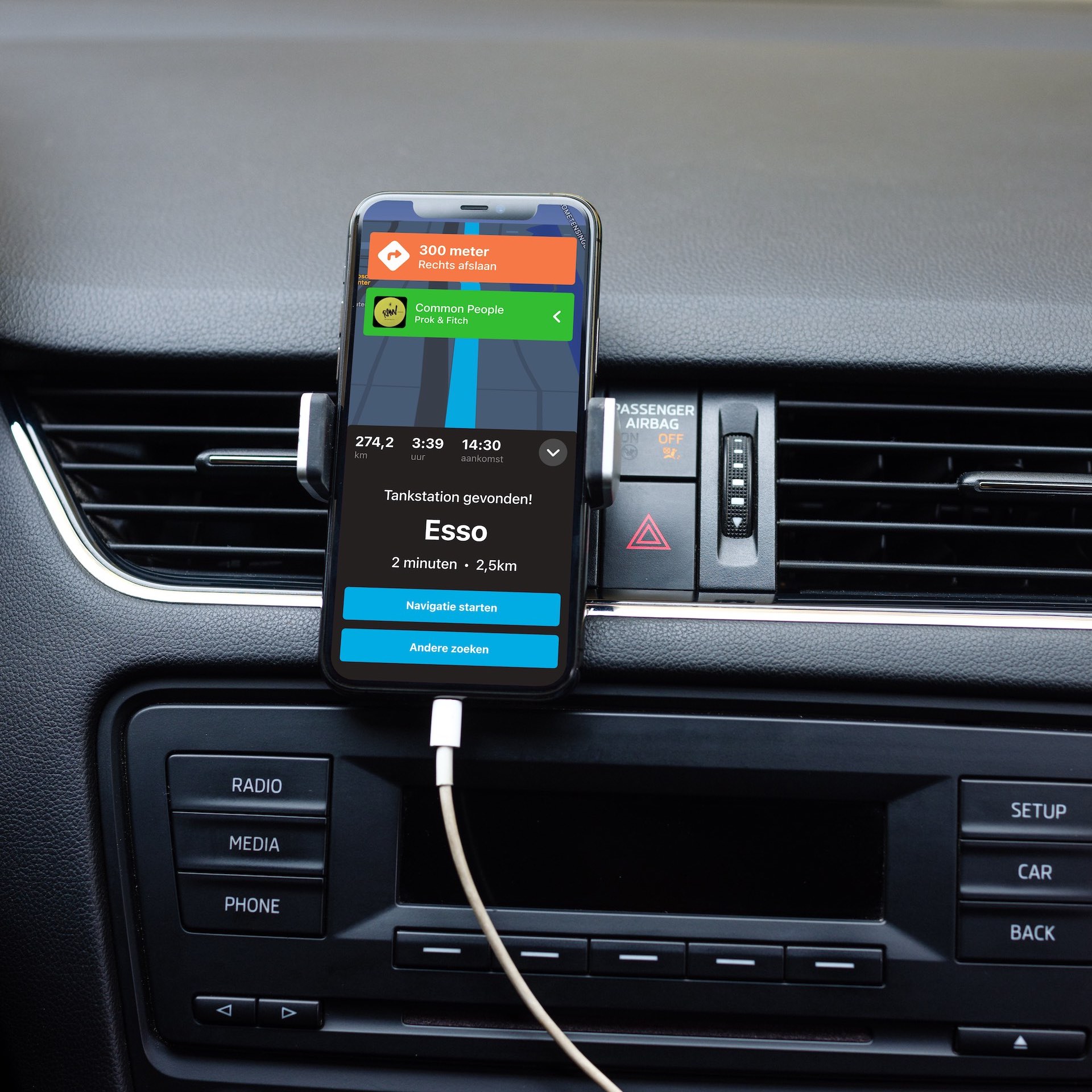 iPhone in een ventilatie-houder in een auto met Triptop op het scherm.